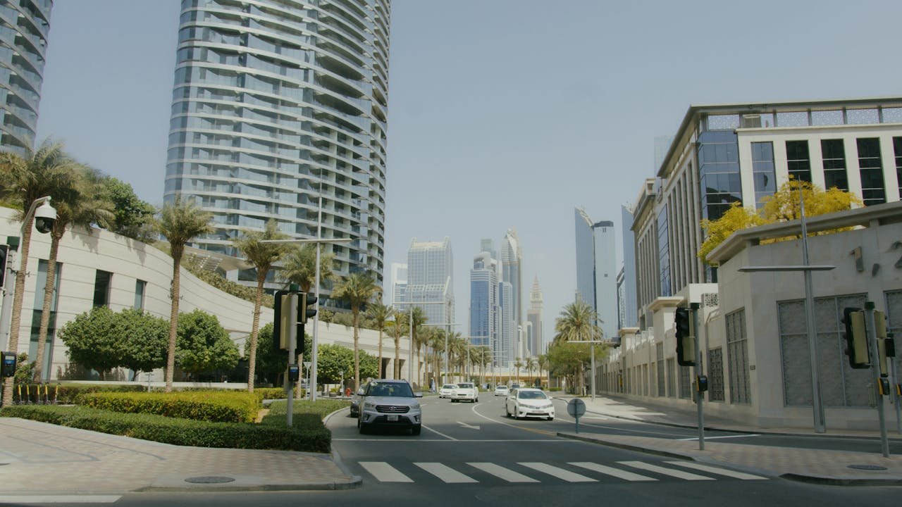 A vibrant urban street view showcasing modern skyscrapers and architecture under a clear sky.